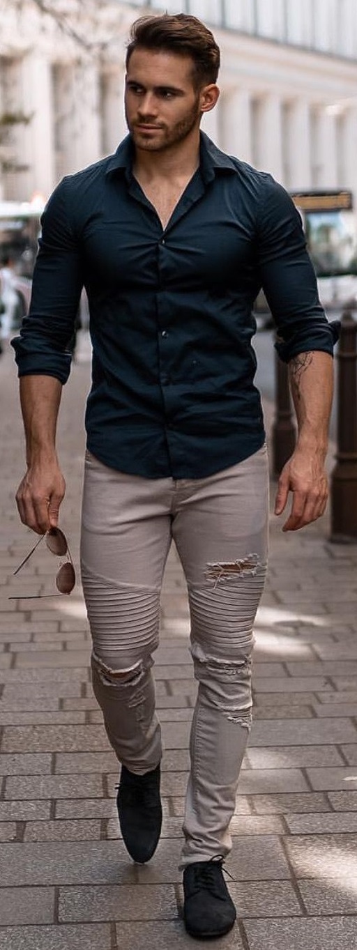 green shirt with beige pants, wearing a black shoe in bottom and shades in hands