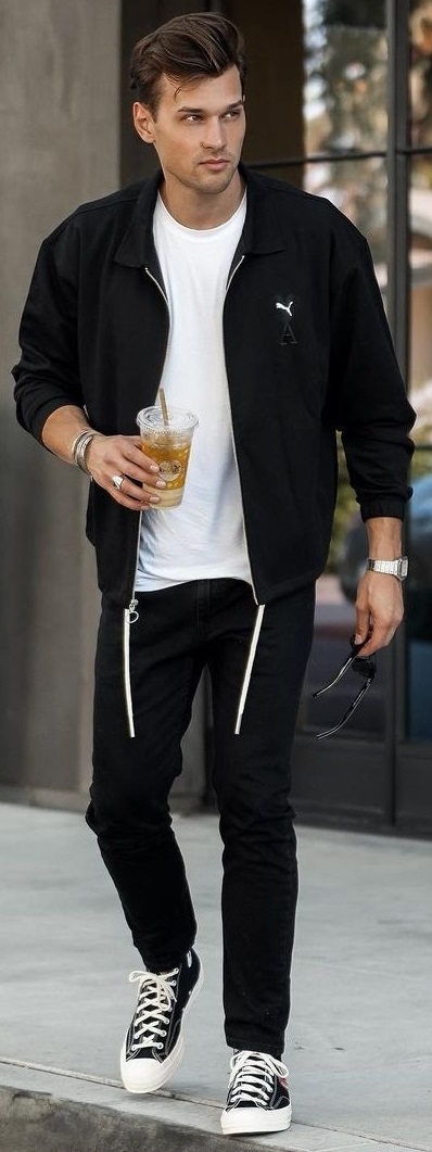 black jacket with black denims and white shoes accessorized with watch