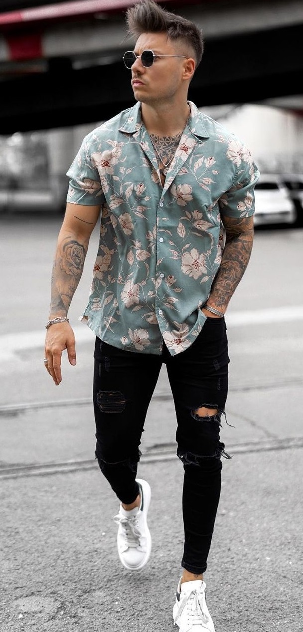 floral green shirt with ripped black denims and white sneakers